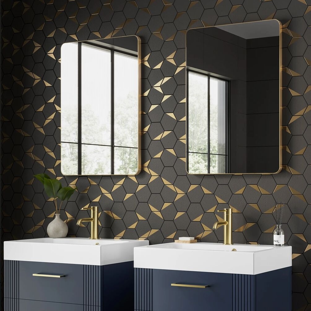 Lifestyle image of the hib. Trim Curve 500mm x 700mm Brushed Brass Bathroom Mirror mounted side by side above two vanity units & basins